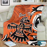 Personalized orange Haida eagle blanket with “Your Text” and bold eagle artwork on living room chair