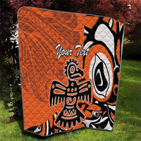 Orange quilt with Haida-style eagle graphic and “Your Text” in black and white on grass