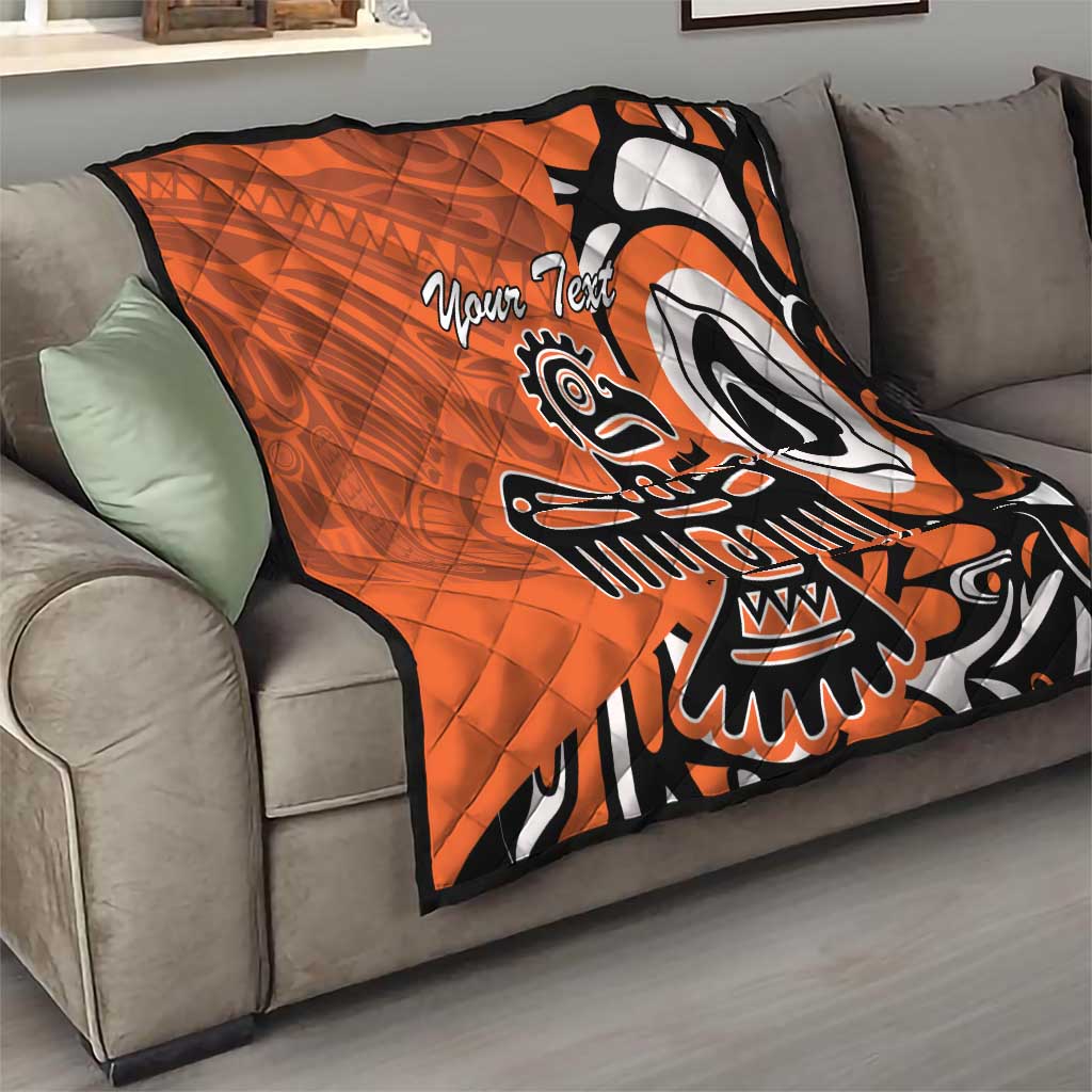 Orange quilt with Haida-style eagle graphic and “Your Text” on a gray sofa, black/white