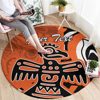 Orange round carpet with central eagle mask graphic in black, white, and orange