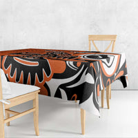 Orange and black patterned tablecloth draped over dining table