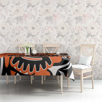 Orange, black, and white patterned tablecloth covering dining table