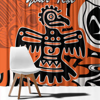 Orange curtain close-up with bold eagle and Haida-style design in black and white