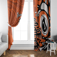 Orange and black-and-white eagle window curtain panels framing a white door