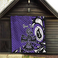 Purple quilt with custom text and Haida-style eagle graphic hanging on a wall