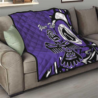 Purple quilt with custom text and Haida-style eagle graphic draped over a sofa