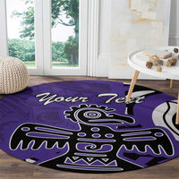 Round purple area rug with eagle graphic, laid on hardwood floor near window