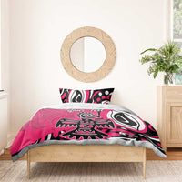 Pink bedding set on bed with duvet and two pillowcases featuring eagle artwork