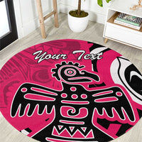 Pink round area rug with central Haida-style eagle face and 'Your Text' script