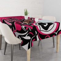 Pink tablecloth draped over dining table, featuring bold black-and-white eagle motif