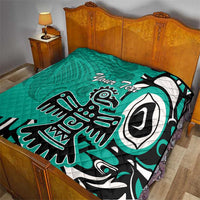Turquoise quilt with bold Haida eagle artwork and custom text, on bed