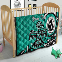 Turquoise personalized quilt with Haida eagle graphic and “Your Text,” on toddler bed