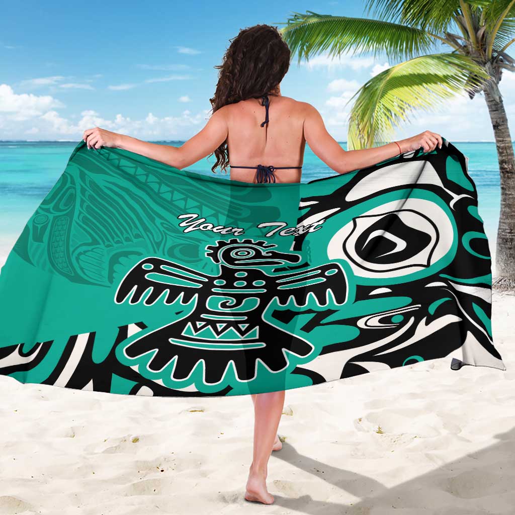 Turquoise sarong with eagle/Haida style artwork, black trim, and “Your Text”