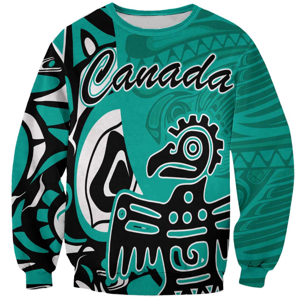 Turquoise sweatshirt with 'Canada' print and Haida-style eagle face