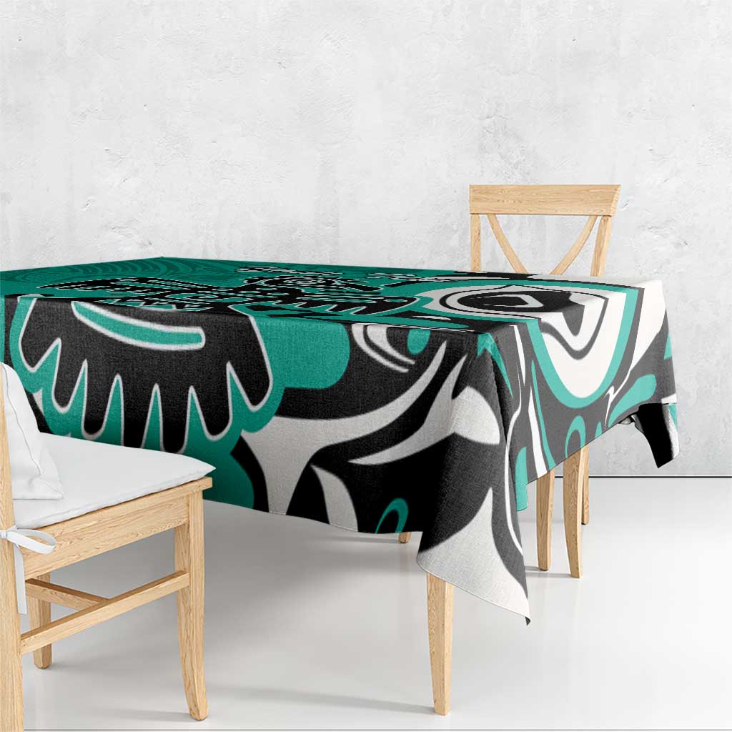 Turquoise tablecloth with black and white eagle graphic, laid over dining table edge