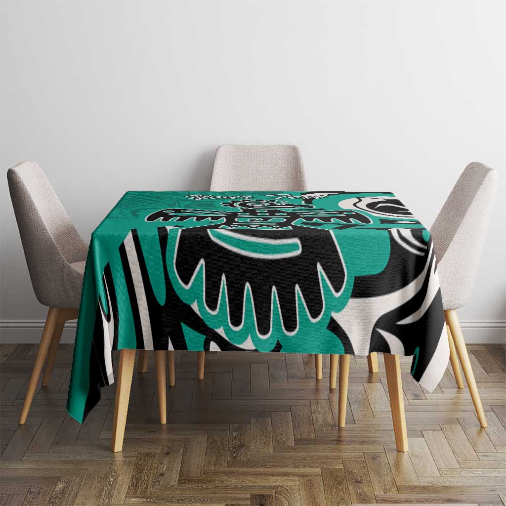 Turquoise tablecloth with black and white tribal eagle pattern, draped over square table