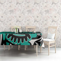 Turquoise tablecloth featuring black and white eagle pattern, on dining table and chairs