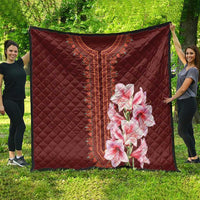 Maroon/red quilt blanket with diamond quilting, decorative central border and pink lilies