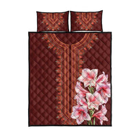 Red quilt bed set with two pillow shams; ornate center panel and pink lily floral