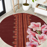 Round burgundy carpet with red geometric stripe and pink lilies in lower right