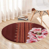 Round burgundy carpet with red geometric center stripe and large pink lily cluster