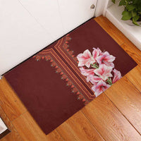 Burgundy rubber doormat with central pink lily bouquet and decorative red border