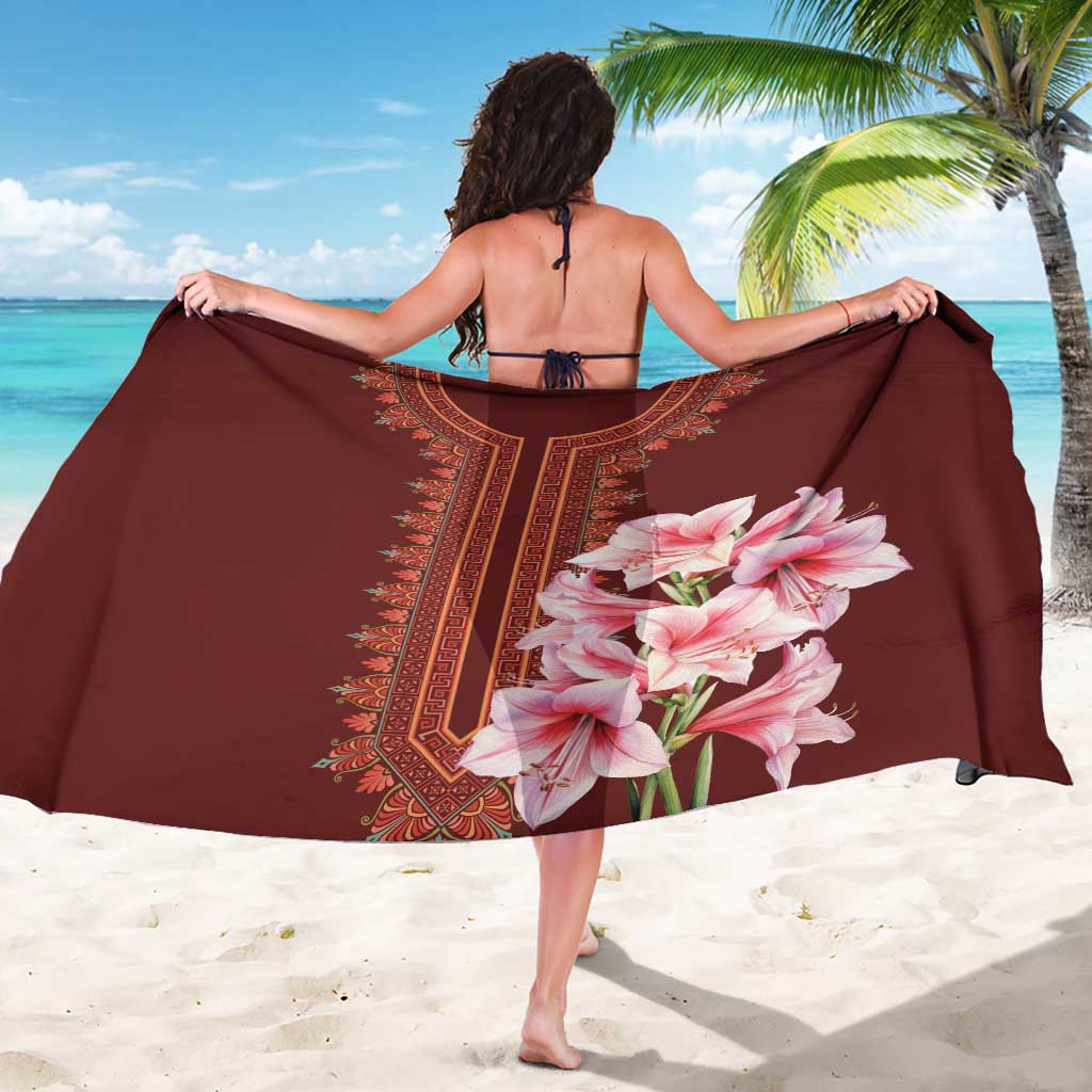 Dark maroon sarong held open, pink lily print with geometric dashiki border center.