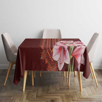 Red tablecloth with pink lily bouquet and woven-style center stripe