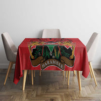 Red tablecloth with centered coat of arms emblem and multicolor Kente-style motifs