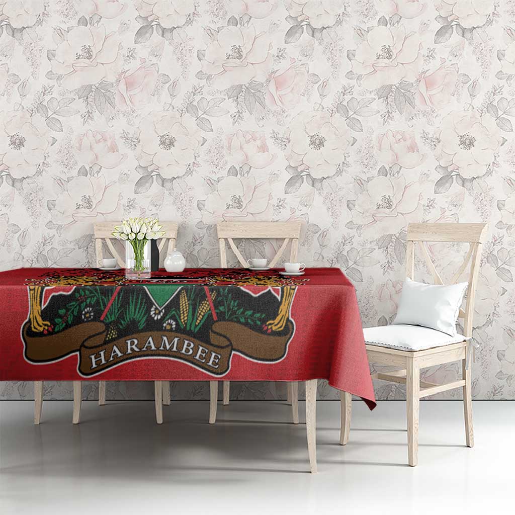 Red tablecloth with coat of arms graphic and Kente-style trim in green and gold