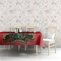 Red tablecloth with coat of arms graphic and Kente-style trim in green and gold