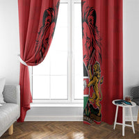 Red Kenya curtain panels with coat of arms print, hung over a window