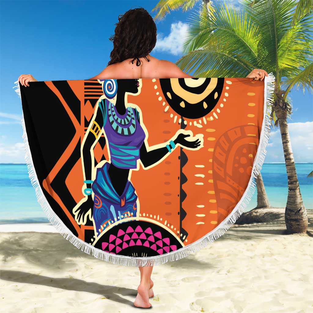Round orange beach blanket with bold African woman illustration and geometric patterns, fringe