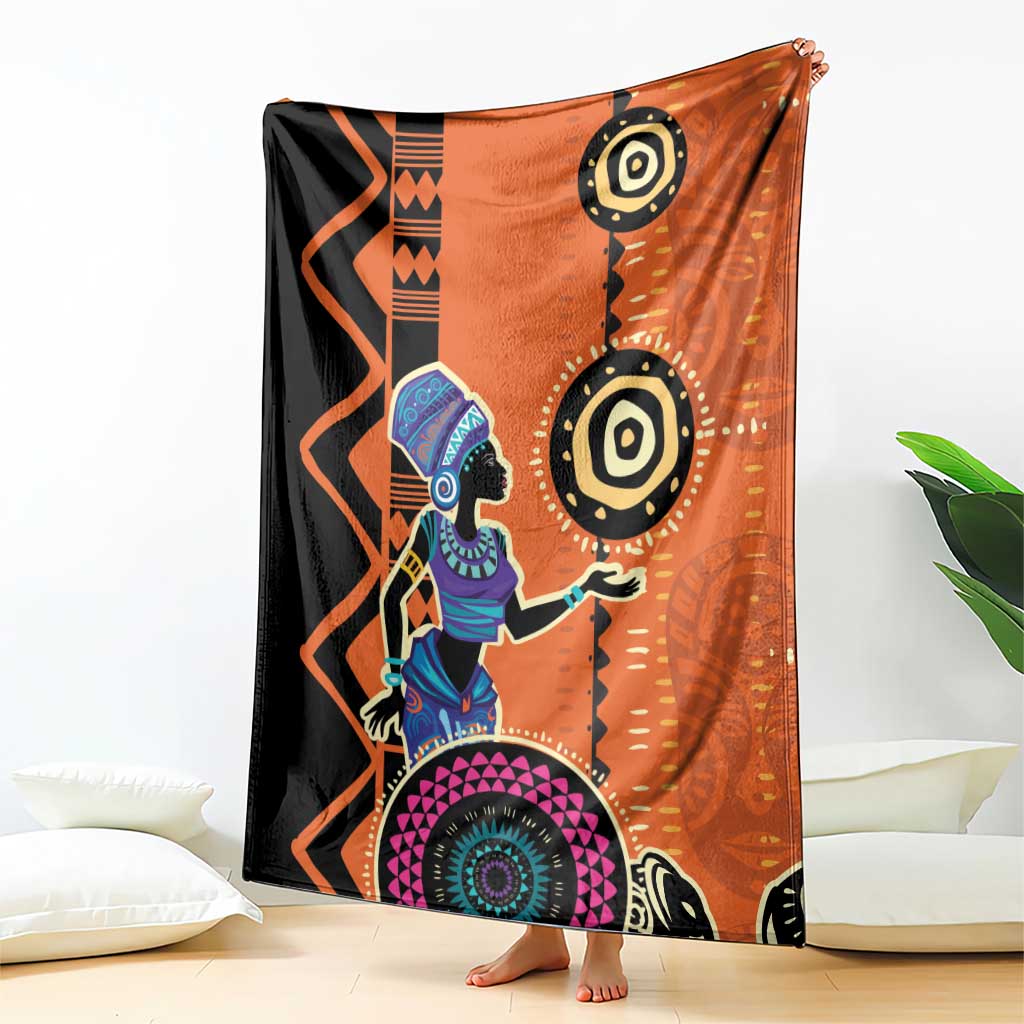 Orange and black blanket draped on floor with African woman artwork and bold mandala