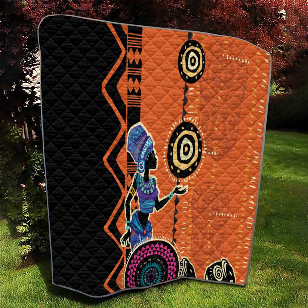 Orange and black quilt blanket with tribal woman graphic and circular motifs
