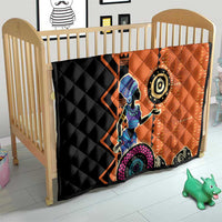 Orange and black quilt blanket in a baby crib with tribal geometric woman design