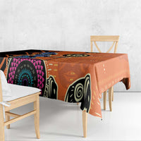 Orange tablecloth draped over table edge with black-and-white animal-like mask motif