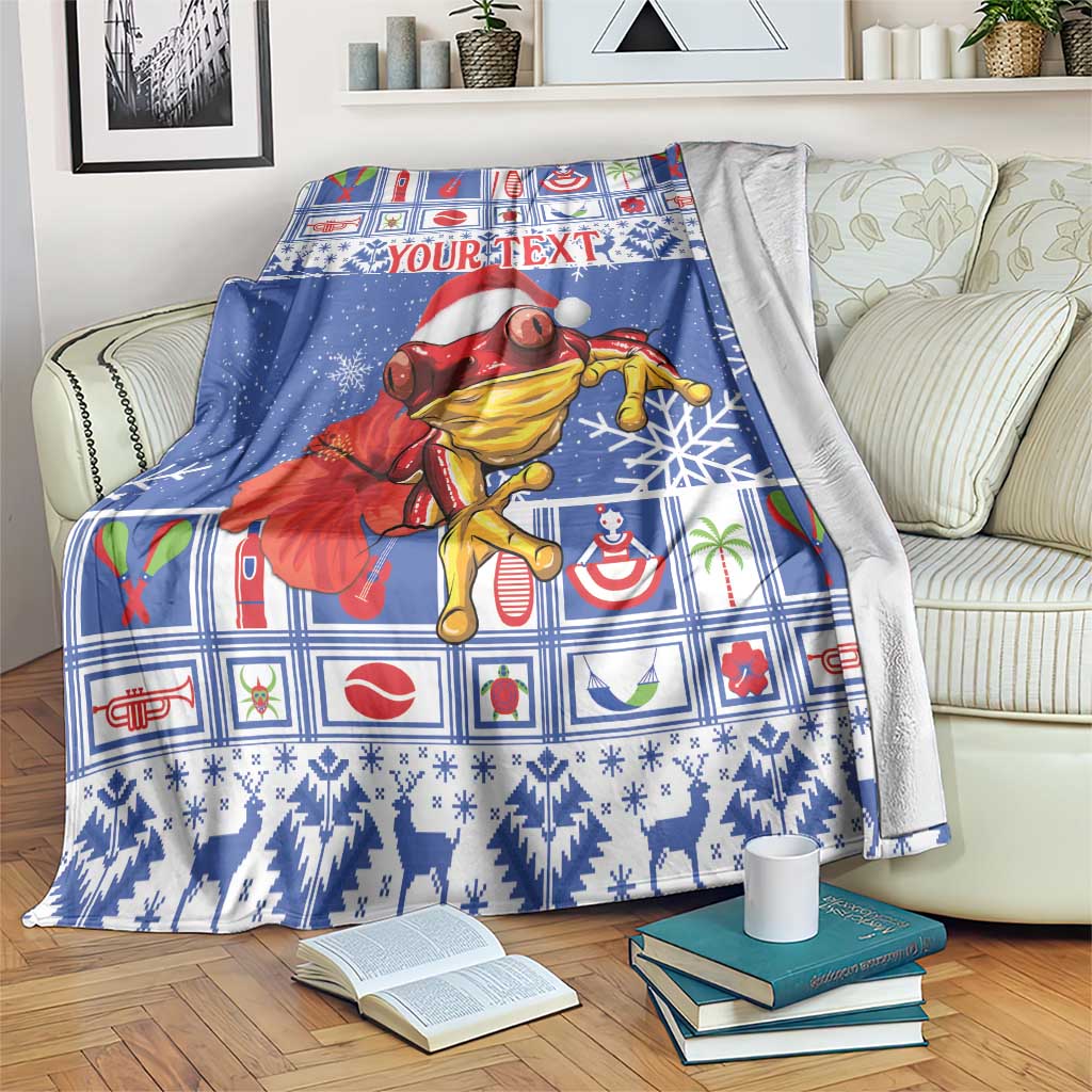 Blue personalized Christmas blanket with coqui in Santa hat and colorful Puerto Rico pattern