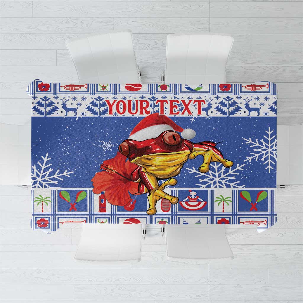 Blue personalized Christmas tablecloth with coqui character and 'YOUR TEXT' panel.