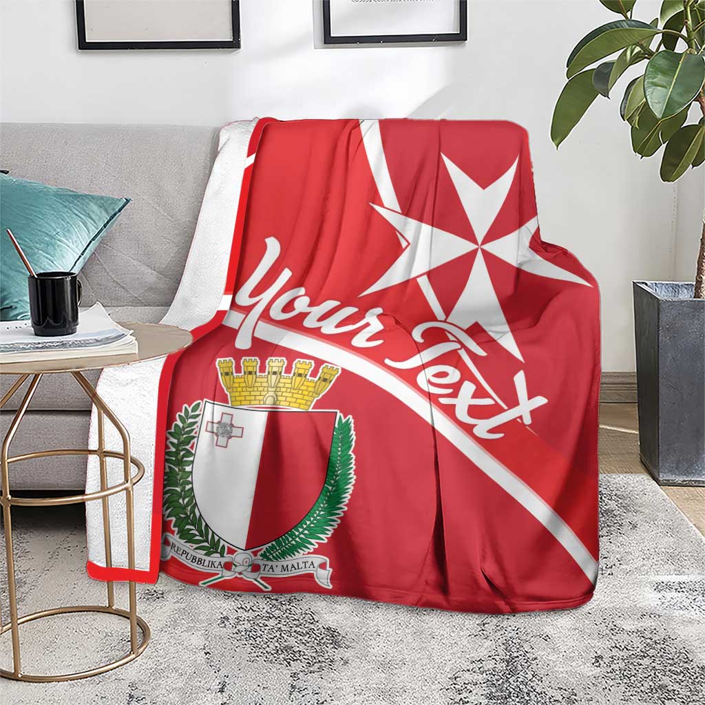 Red Malta coat of arms blanket with white Maltese cross, laid on gray couch seat
