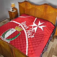 Red quilt blanket on bed with Malta cross, crest shield, and white script