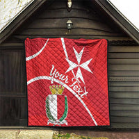 Red Malta cross quilt blanket hanging on exterior wall with crest shield