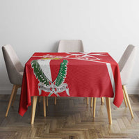 Red tablecloth featuring white Malta cross and green-and-red coat of arms shield center.