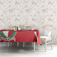 Red printed tablecloth with white Malta cross and coat of arms shield on a dining table.