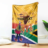 Personalized heritage blanket on sofa, yellow chevrons with dancer, masks, and “YOUR TEXT”