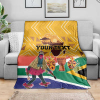 Personalized South Africa heritage blanket on gray sofa, yellow design with dancer and masks