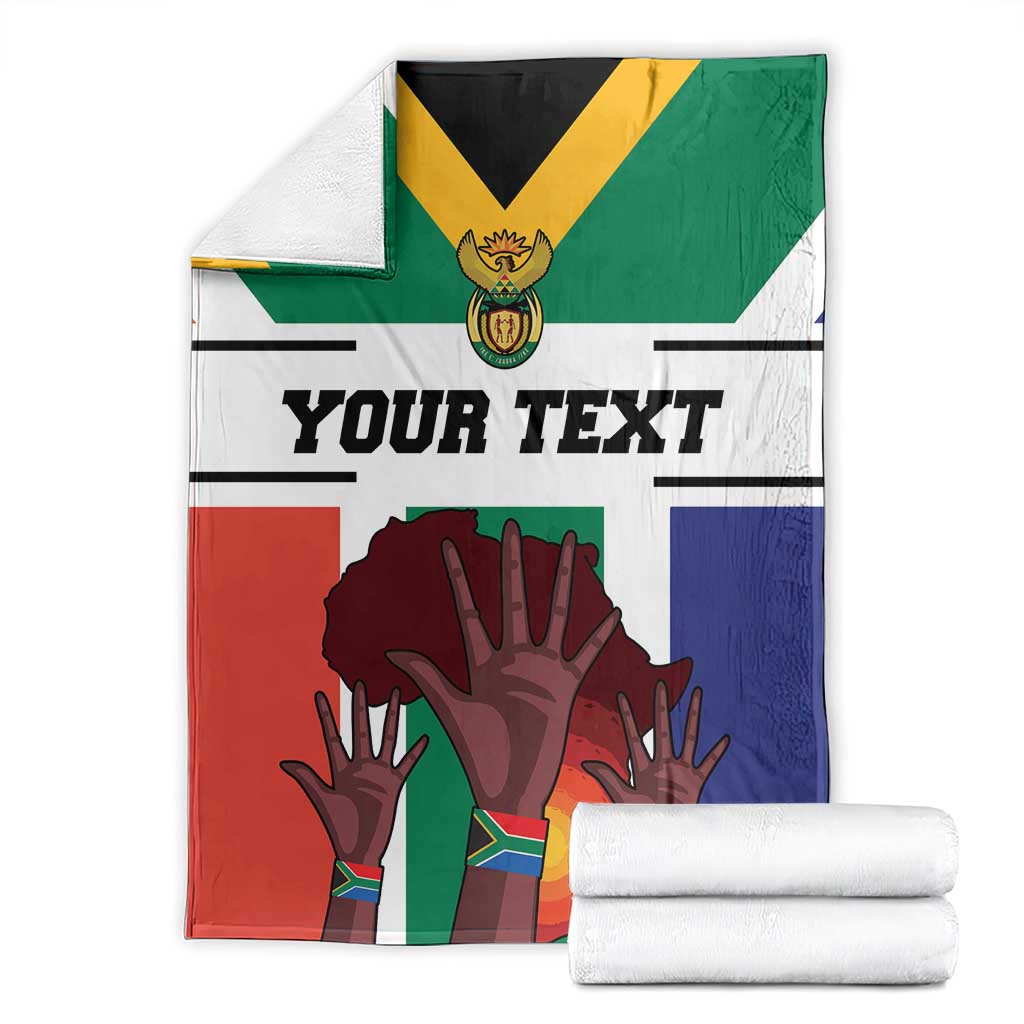 Folded South Africa flag-style blanket with 'Your Text' and hands graphic, plus rolled towels