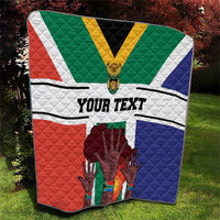 Personalized quilt outdoors with South Africa flag colors, 'YOUR TEXT' and quilted hands