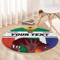 Round personalized carpet with 'YOUR TEXT' and flag-style hands in green and dark red