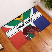 Personalized South Africa flag doormat showing 'YOUR TEXT' and colorful hand graphics